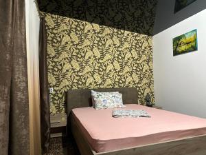 Dormitorio pequeño con cama rosa y pared en Pensiunea Alessia Murighiol, en Murighiol