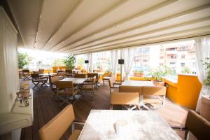 a restaurant with tables and chairs and windows at Classic Hotel in Tirana