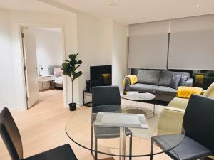 - un salon avec un canapé et une table dans l'établissement Upper Riverside O2 2Bedroom Flat 05, à Londres