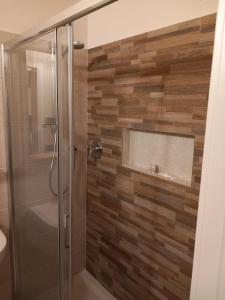 y baño con ducha y pared de madera. en La collinetta B&B en Crespellano
