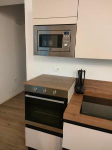 a kitchen with a microwave above a stove at B&B il Santo in Castelleone di Suasa