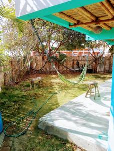 a hammock in a yard with a bench and a fence at Hostal Puerto Engabao Surf Shelter in Engabao