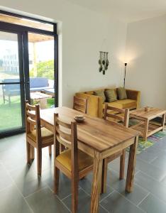 a living room with a wooden table and chairs at SK Stay-Condo in The Soul with private terrace 300m Paje Beach in Paje