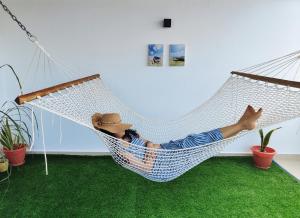 a man laying in a hammock in a room at SK Stay-Condo in The Soul with private terrace 300m Paje Beach in Paje