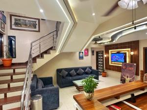 a living room with a couch and a staircase at Hotel Gurukripa Inn in Godarpura