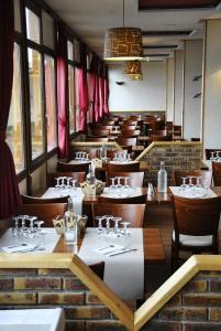 un comedor con mesas, sillas y cortinas rojas en La Berangere, en Chamrousse