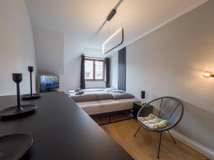 ein Schlafzimmer mit einem Bett, einem Tisch und einem Stuhl in der Unterkunft Rathausblick – Moderne Ferienwohnung mit 2 Schlafzimmern, Küche, Bad, Waschmaschine & Trockner mitten in der Innenstadt in Leipzig