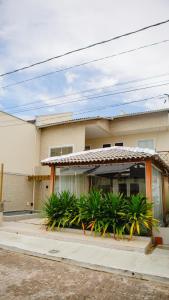 uma casa com palmeiras em frente em Casa com Píer à Beira do Rio Preguiças em Condomínio Fechado em Barreirinhas