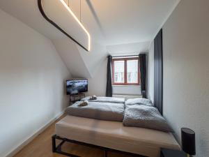 ein Schlafzimmer mit einem Bett und einem Fenster in der Unterkunft Rathausblick – Moderne Ferienwohnung mit 2 Schlafzimmern, Küche, Bad, Waschmaschine & Trockner mitten in der Innenstadt in Leipzig