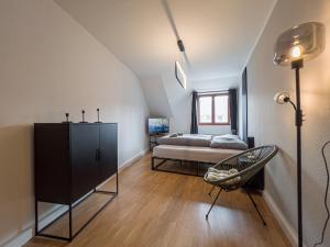 ein Schlafzimmer mit einem Bett und einem Stuhl in einem Zimmer in der Unterkunft Rathausblick – Moderne Ferienwohnung mit 2 Schlafzimmern, Küche, Bad, Waschmaschine & Trockner mitten in der Innenstadt in Leipzig