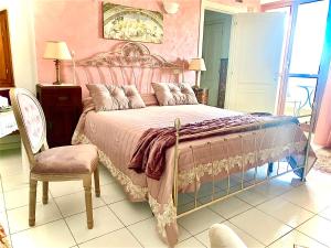 a bedroom with a large bed and a chair at CasAzzurra in Ortona