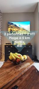 a bowl of fruit on a table in a room at Maison Village Cosy - Wifi - 2 VTT - 5 km plage in Villelongue-de-la-Salanque