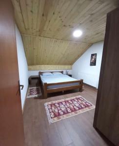 Villa Albani في بيخا: غرفة نوم بسرير وسقف خشبي