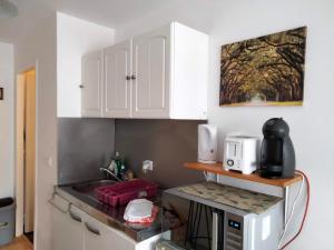 une cuisine avec des armoires blanches et un micro-ondes dans l'établissement Studio à côté de la plage, à Hendaye
