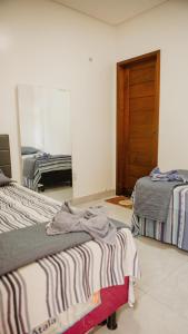 1 dormitorio con 2 camas y puerta en Casa com Píer à Beira do Rio Preguiças em Condomínio Fechado en Barreirinhas
