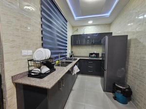 a kitchen with a refrigerator and a counter top at Genesis Grid Homes - Petra in Lekki