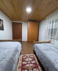 1 Schlafzimmer mit 2 Betten und Holzdecke in der Unterkunft Villa Albani in Peja