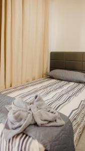 a blanket laying on a bed in a bedroom at Casa com Píer à Beira do Rio Preguiças em Condomínio Fechado in Barreirinhas