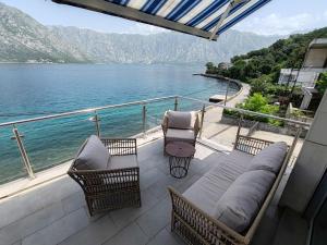 a balcony with chairs and a view of the water at Квартира с прекрасным видом на море in Donji Stoliv