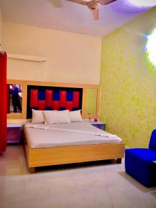 a bedroom with a bed with a red and blue headboard at Malinum Grande Guest House in Lahore