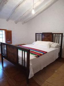 une chambre avec un lit avec une tête de lit en bois dans l'établissement Casa rural Quintina, relax en la Sierra del Segura, à Socovos
