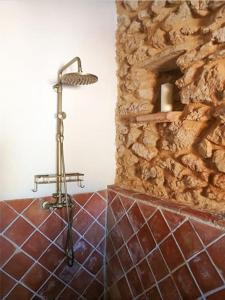 La salle de bains est pourvue d'une douche et d'un mur en pierre. dans l'établissement Casa rural Quintina, relax en la Sierra del Segura, à Socovos