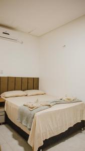 um quarto com uma cama grande e paredes brancas em Casa com Píer à Beira do Rio Preguiças em Condomínio Fechado em Barreirinhas
