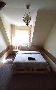1 dormitorio con 1 cama grande y ventana en Pensjonat pod Kasztanem, en Ełk