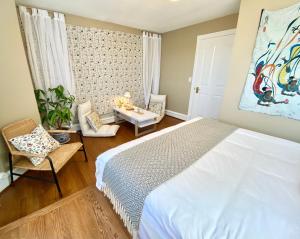 1 dormitorio con 1 cama blanca, mesa y sillas en Gorgeous Private Estate With Ocean and Mountain View en Nanoose Bay