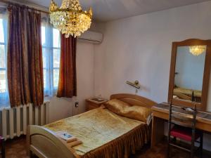 Arbanassi Hotel في ارباناسي: غرفة نوم بسرير ومرآة وطاولة