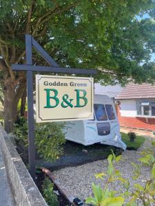 a sign for a garden green bb in front of a van at Godden Green B & B Guesthouse in Newchurch