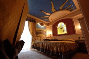 a bedroom with a bed with a star ceiling at Hotel Letizia in San Martino di Castrozza