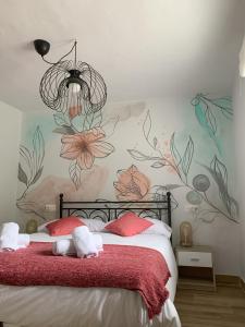 ein Schlafzimmer mit einem Bett mit Blumen an der Wand in der Unterkunft LA ANTIGUA CUADRA precioso apartamento de piedra con jardín, barbacoa y acceso al río in Ramales de la Victoria