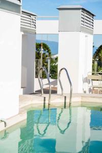 uma piscina com duas cadeiras de metal na água em HOTEL ARENALES em San Fernando del Valle de Catamarca