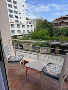 two chairs and a table on a balcony with a view at Durres Lovely Apartment with Balcony in Durrës