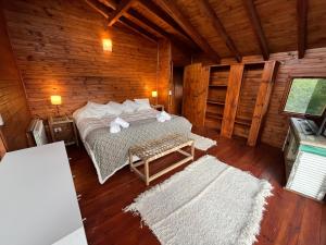 a bedroom with a bed in a wooden cabin at Hogar de Montaña in Villa La Angostura