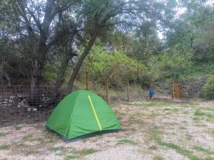 une tente verte dans un champ à côté d'une clôture dans l'établissement El Rebost de Penyagalera, à Beceite