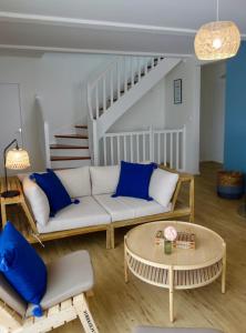 una sala de estar con un sofá y una mesa en House near beach equipped for 8 people, en Barneville-Carteret