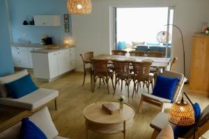 Una sala de estar con mesa y sillas y una cocina. en House near beach equipped for 8 people, en Barneville-Carteret