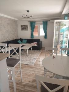 House with pool - Mitrovic في هرسك نوفي: غرفة معيشة مع أريكة وطاولات وكراسي