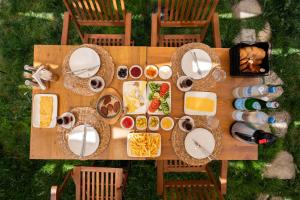 einen Tisch mit Teller mit Lebensmitteln und Flaschen Wein in der Unterkunft TERRA GAİA Hotel in Gokceada Town