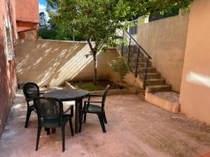 einen Tisch und Stühle neben einer Treppe in der Unterkunft Apart'Hôtel Les 4 Sources in Anduze