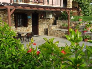 Casa de piedra con mesa y patio en Geomelia Guest Studio 1 & Geomelia Guest Studio 2, en Polígiros