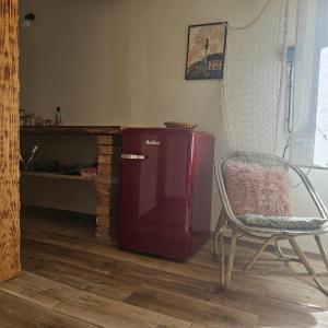 Cette chambre comprend un réfrigérateur rouge, une chaise et une table. dans l'établissement Domek Basia, à Deskurów