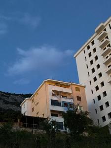 un edificio alto junto a un edificio blanco en Kruja Shared Apartment, en Krujë