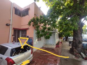 una cinta amarilla atada a un coche estacionado frente a una casa en La casita de Gazcue en Santo Domingo