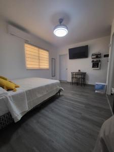 1 dormitorio con 1 cama y TV de pantalla plana en La casita de Gazcue en Santo Domingo