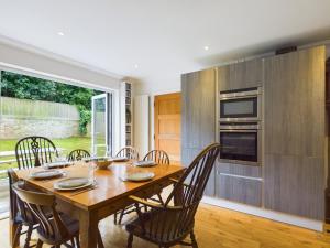 Un comedor con mesa y sillas de madera. en Queens Mews a contemporary beach side holiday home for 6, en Ryde