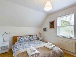 een slaapkamer met een bed met twee handdoeken erop bij Queens Mews a contemporary beach side holiday home for 6 in Ryde
