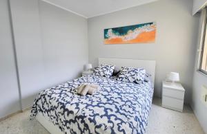 una camera da letto con un letto con lenzuola blu e bianche di Cristimar Roja Beach a Los Cristianos Altre 17 foto